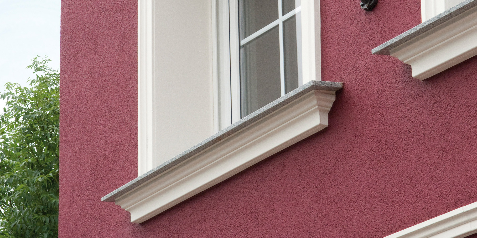 Fensterbank Profile aus Stuck unterhalb der Fenster bilden einen schönen Abschluss an der Hausfassade.